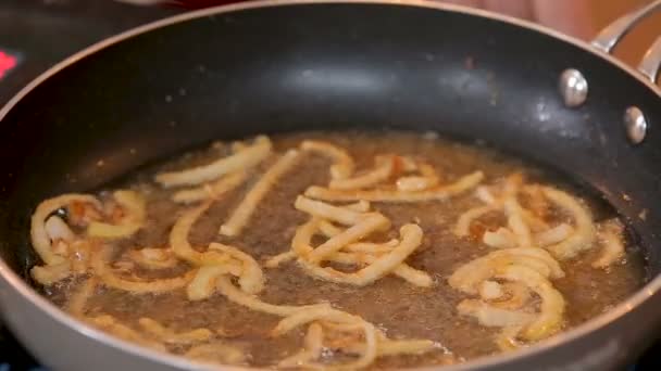 Crispy fried onion rings on a pan — Stok video