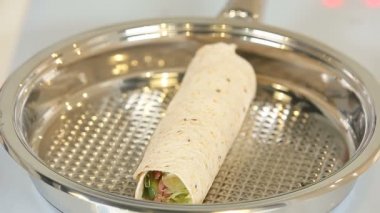 Roll of pita bread in a frying pan