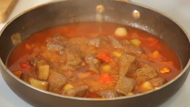 Matlagning gulasch nötkött gryta med grönsaker i en kastrull — Stockvideo