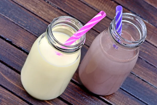 Flaschen mit Schokolade und Bananen-Milchshake — Stockfoto