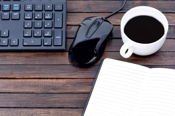 Kaffeetasse mit Notizblock und Tastatur auf dem Tisch — Stockfoto
