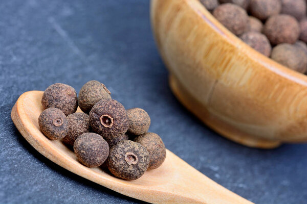 Allspice in a spoon and bowl