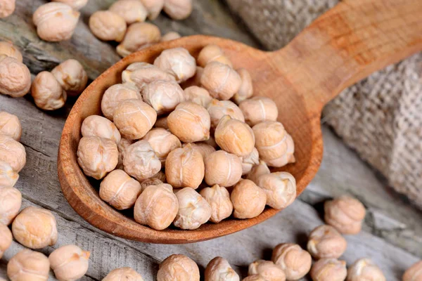 Pois chiches dans une cuillère en bois — Photo