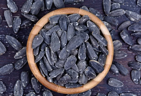 Black sunflower seeds in a bamboo bowl — Stock Photo, Image