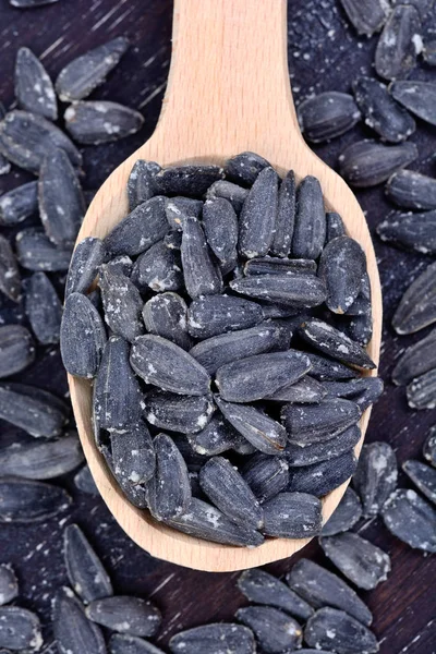 Black sunflower seeds in a spoon on table — Stock Photo, Image