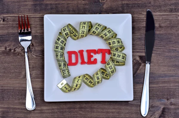 Palabra de dieta con centímetro en plato blanco —  Fotos de Stock