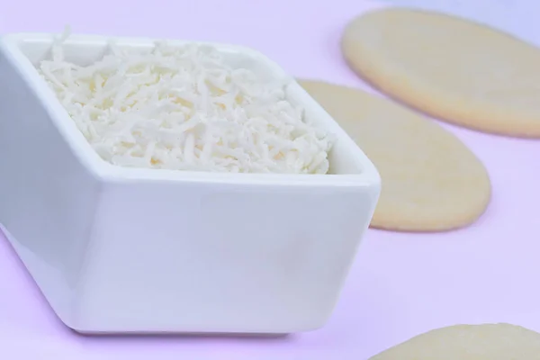 Cheese in a ceramic bowl and dough on table — Stock Photo, Image