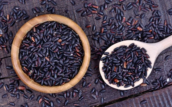 Arroz preto em uma tigela e colher na mesa — Fotos gratuitas