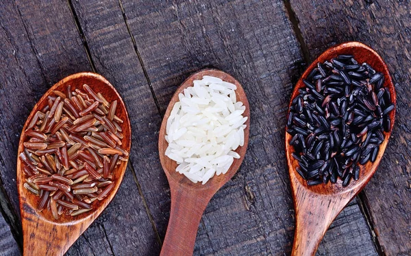 Dřevěné lžíce s různými druhy rýže — Stock fotografie