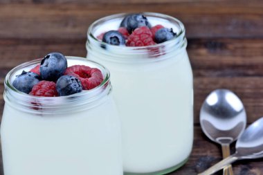 Yoğurt ans ile masada çeşitli meyveler kavanozlar