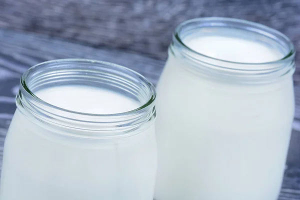 Yogurt in a jars glass on table — Stock Photo, Image