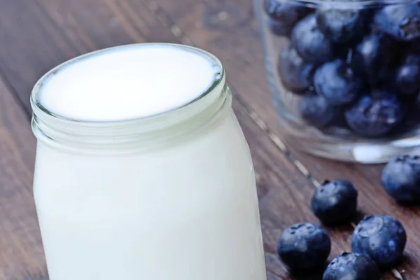 Glass with yogurt and blueberry on table — Stock Photo, Image