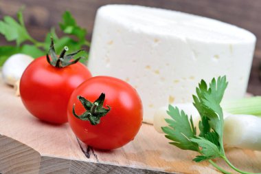 Domates peynir, maydanoz ve soğan ahşap arka plan üzerinde