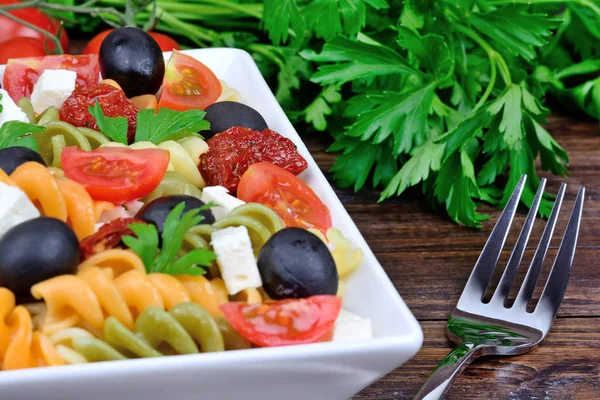 Pasta colorata con verdure e forchetta in tavola — Foto Stock