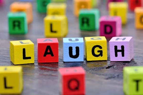 La palabra risa en la mesa —  Fotos de Stock