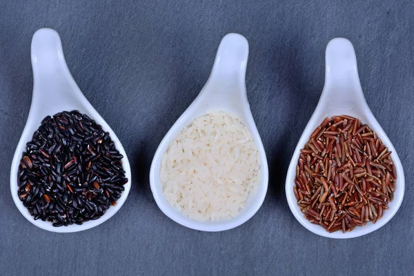 Lžíce s různými druhy rýže — Stock fotografie