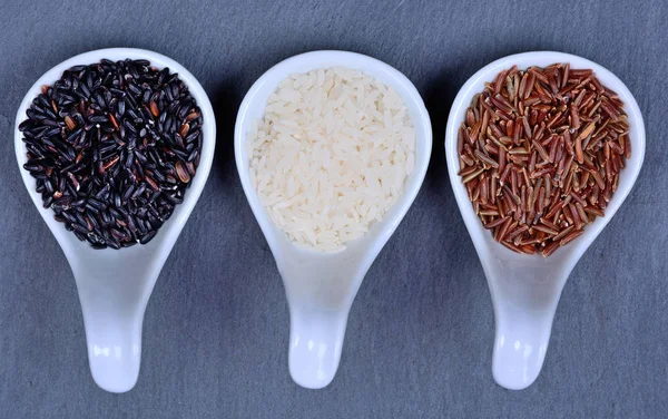Keramické lžičky s různými druhy rýže — Stock fotografie
