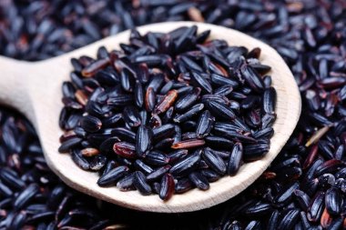 Tahta kaşıkta siyah pirinç.