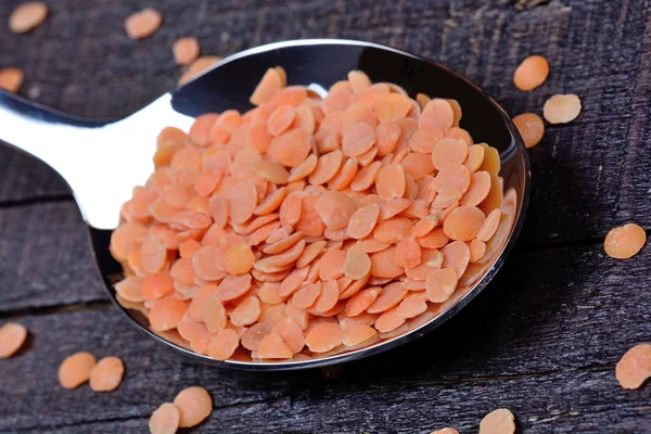 Colher com lentilhas vermelhas na mesa — Fotografia de Stock