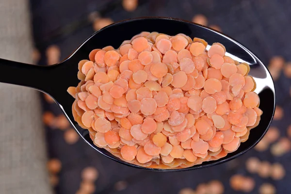 Colher de metal com lentilhas vermelhas — Fotografia de Stock