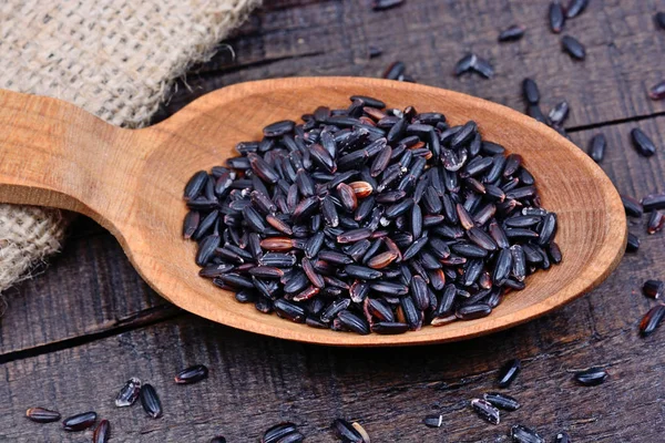 Black rice in a spoon on table — Stock Photo, Image