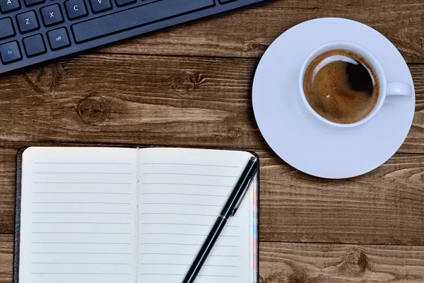 Tastatur-Computer mit Notizblock und Kaffee auf dem Tisch — Stockfoto