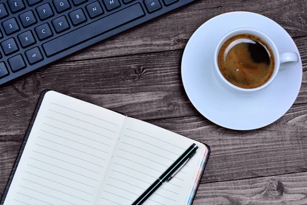 Notizbuch mit Tastatur und Kaffeetasse auf dem Schreibtisch — Stockfoto