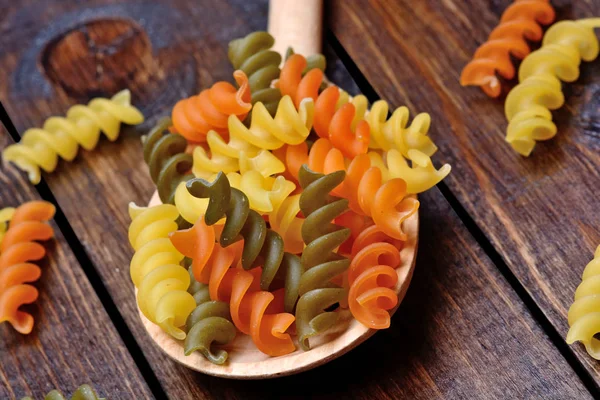 Colorful pasta in a spoon on table — Stock Photo, Image