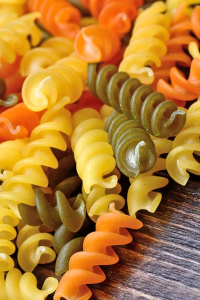 Colorful pasta on wooden table — Stock Photo, Image