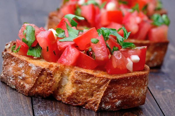 Bruschetta with tomatoes and garlic on table — Stock Photo, Image