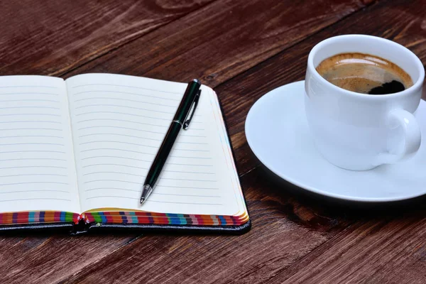 Notizbuch mit Kaffee auf dem Tisch — Stockfoto