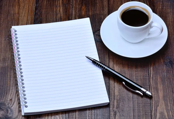 Bloc de notas con pluma y café en la mesa — Foto de Stock