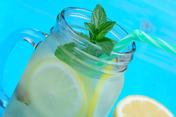 Вода с лимоном и мятой в стеклянной банке на столе — стоковое фото