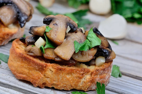 Mushroom bruschetta on wooden table — Stock Photo, Image