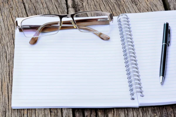 Notizblock mit Stift und Brille auf dem Tisch — Stockfoto