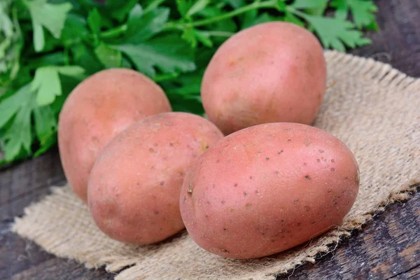 Patatas rojas crudas con perejil en la mesa — Foto de Stock