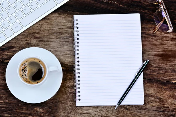 Notizblock mit Kaffee und Tastaturcomputer auf dem Tisch — Stockfoto