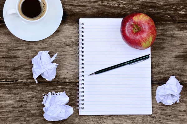 コーヒーりんごとテーブルにしわくちゃの紙メモ帳 — ストック写真
