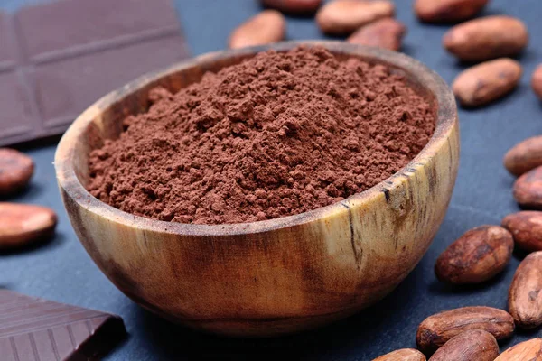 Миска з какао порошком і шоколадом на шифері — стокове фото