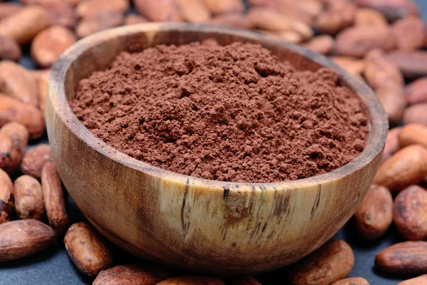 Birçok kakao çekirdekleri ile kayrak bir kapta toz — Stok fotoğraf