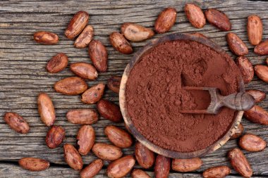 Bir kase ve fasulye rustik masada kakao tozu