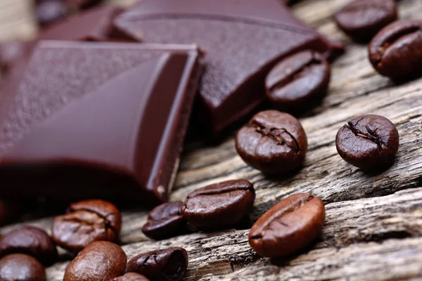 Mörk choklad med kaffebönor på träbord — Stockfoto