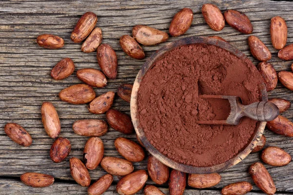 Bir kase ve fasulye rustik masada kakao tozu