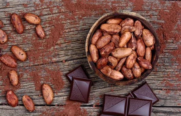 Какао-боби з темним шоколадом на столі — стокове фото