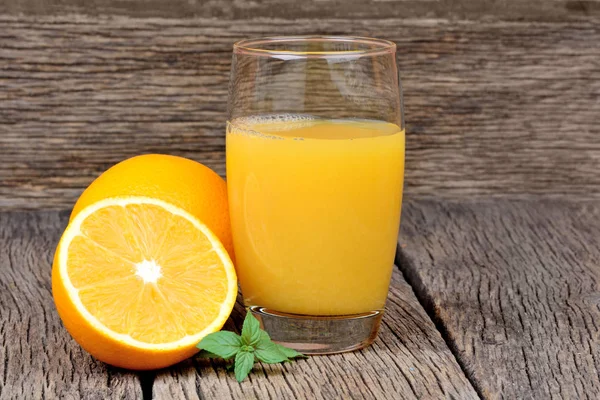Апельсиновый сок в стакане на фоне дерева — стоковое фото