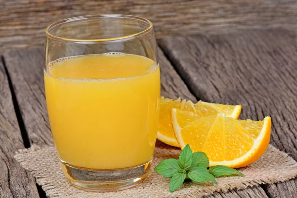 Jus d'orange dans un verre sur fond bois — Photo