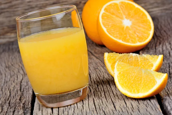 Szkło z soku pomarańczowego na drewnianym stole — Zdjęcie stockowe