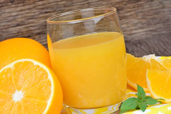 Jus d'orange dans un verre avec des fruits sur fond en bois — Photo