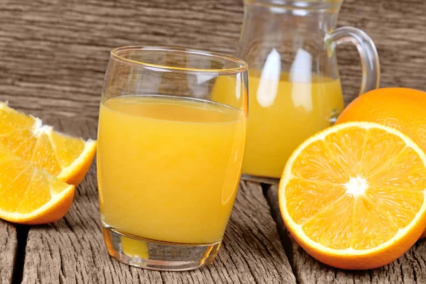 Jus d'orange dans un verre et pichet sur la table — Photo