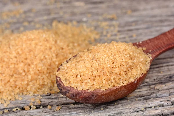Bir tahta kaşık masa üzerinde kahverengi şeker